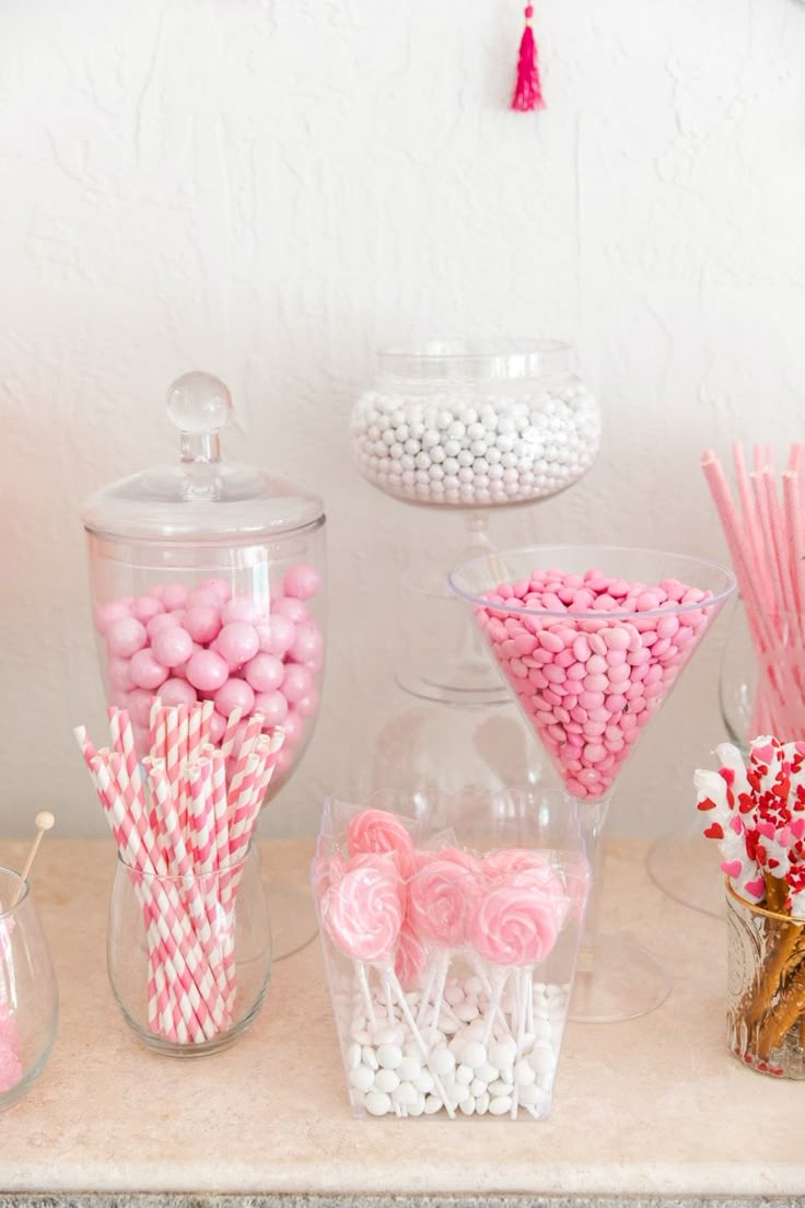 pink and white candies, lollipops, marshmallows in glass containers