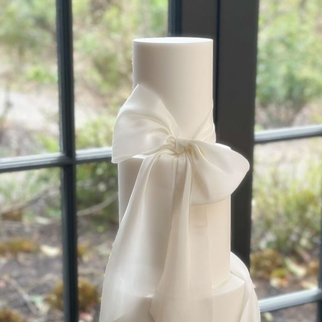 a white wedding cake sitting on top of a table