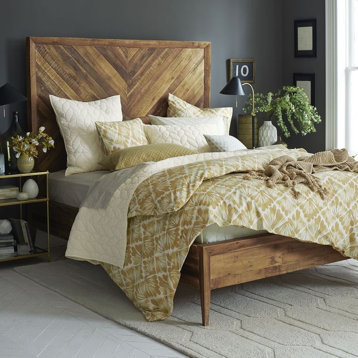 a bedroom with a large bed and wooden headboard in the center, along with two nightstands