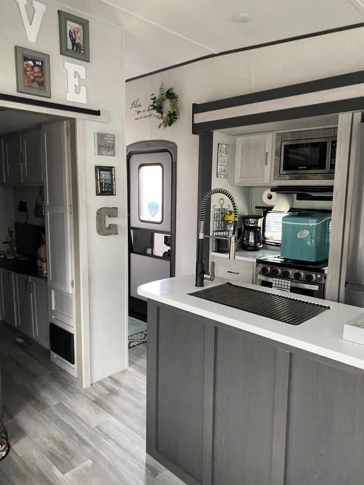 an rv kitchen with stainless steel appliances and wood flooring