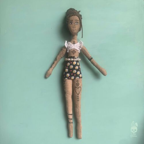 a doll is hanging on the wall in front of a blue background with an image of a woman's body