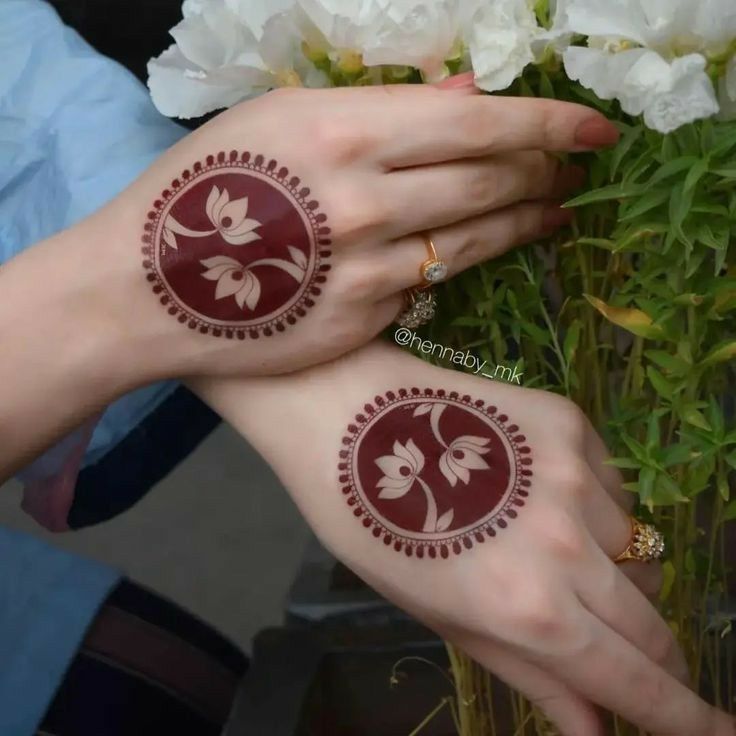 two women with henna tattoos on their hands and one is holding a bouquet of flowers