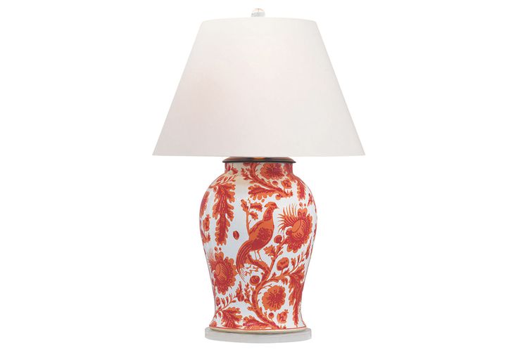 a red and white vase with a lamp on it's side, against a white background