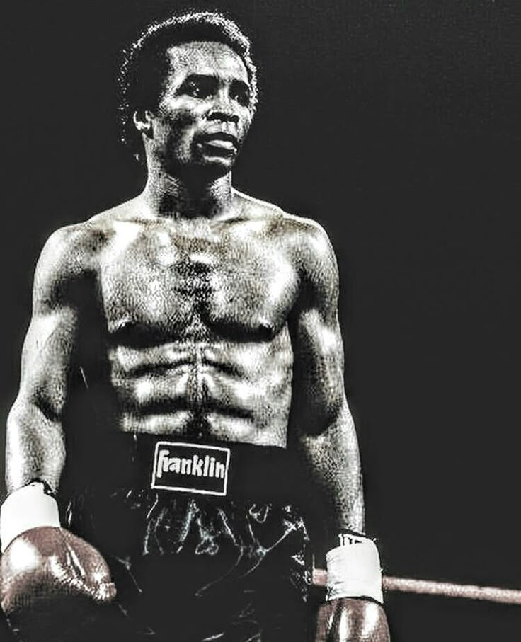 a black and white photo of a man wearing boxing gloves