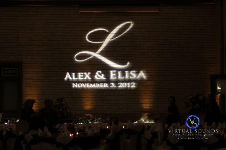 the logo for alex & elsiaa is projected on a brick wall at night