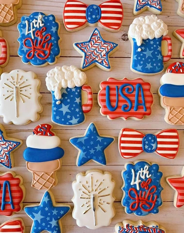 patriotic decorated cookies are arranged on a wooden surface with the word usa spelled in red, white and blue