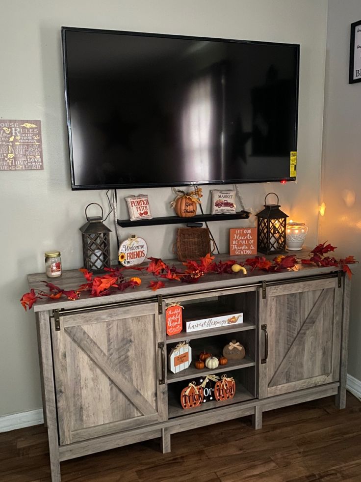 a flat screen tv mounted on top of a wooden entertainment center