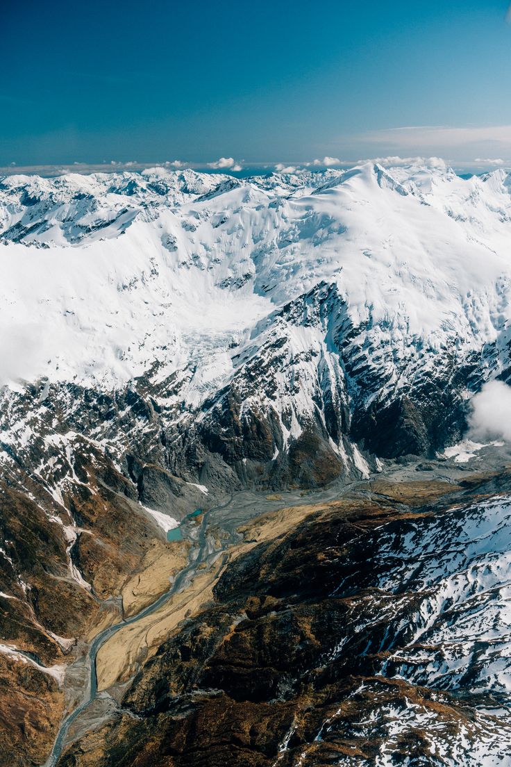 an aerial view of snow covered mountains and rivers