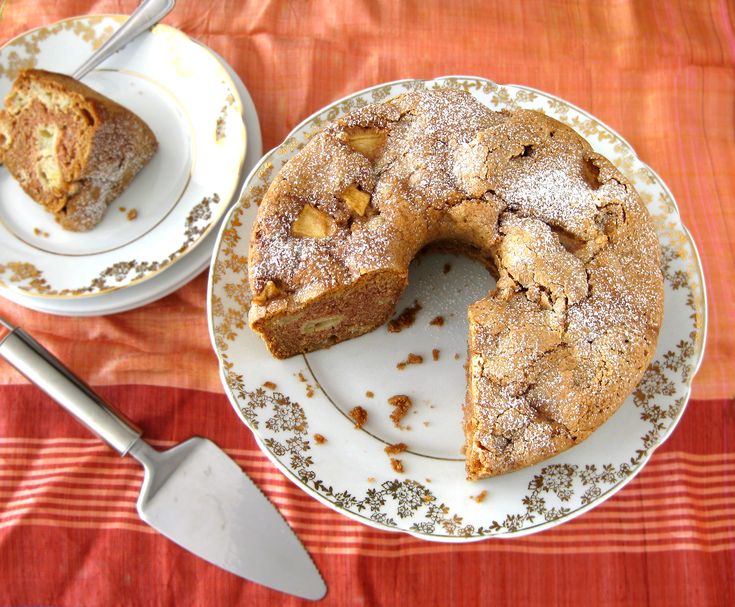 a plate with a cake on it next to a knife and fork