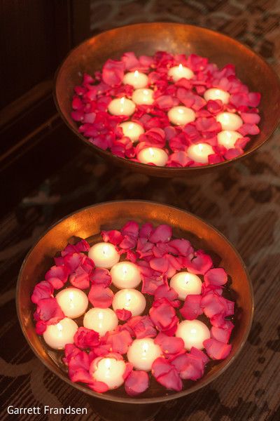 two bowls filled with floating candles and roses