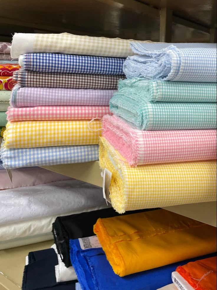 several folded towels are stacked on top of each other in different colors and patterns,