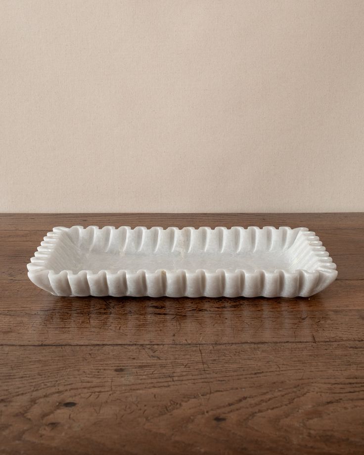 a white ceramic dish sitting on top of a wooden table