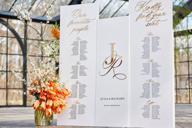 a table plan with flowers in a vase and an orange flower arrangement on the side