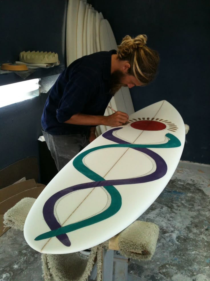 a woman standing next to a surfboard on top of a table