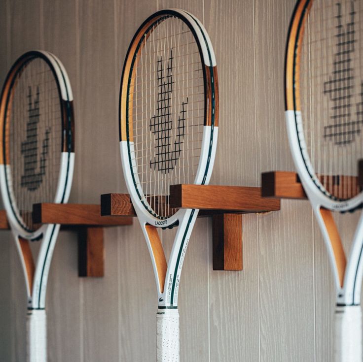 three tennis rackets are hanging on the wall