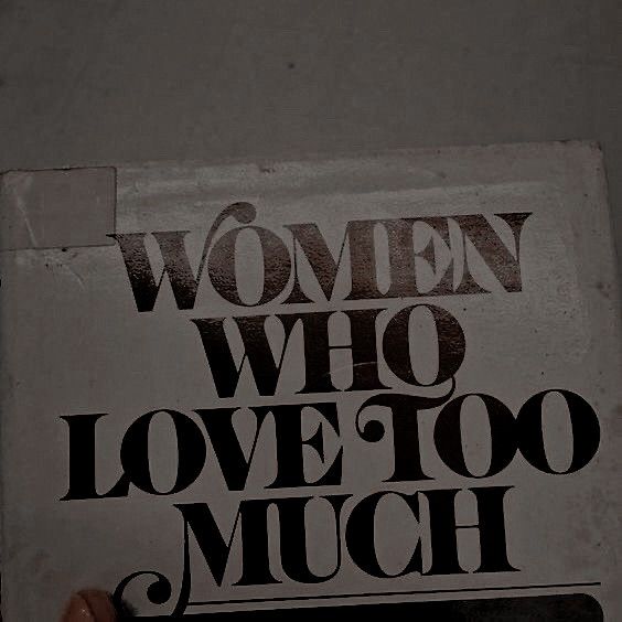 a woman who love too much is holding up a sign that reads women who love too much