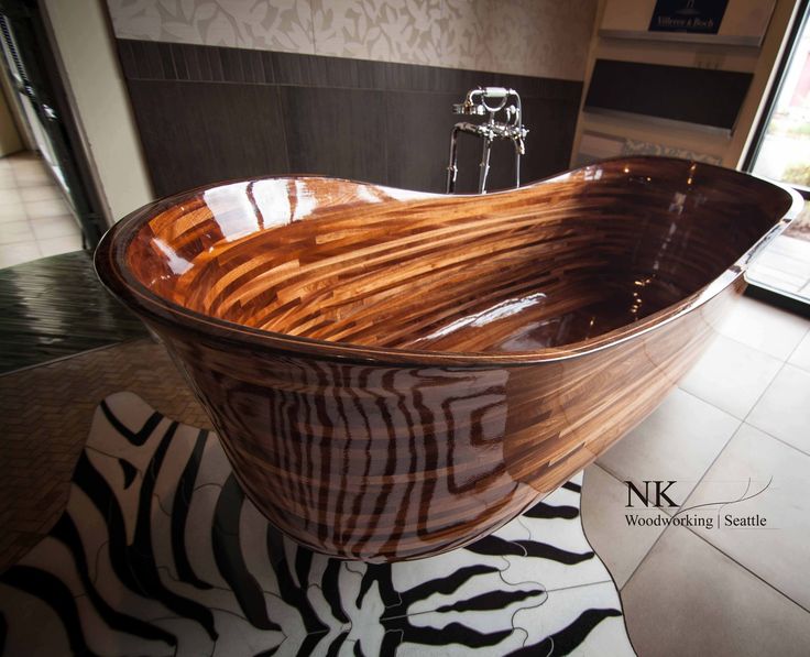 a large wooden bath tub sitting on top of a tiled floor