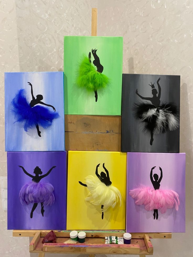 an art display with paintings of dancers on canvases in different colors and sizes, including tutu skirts