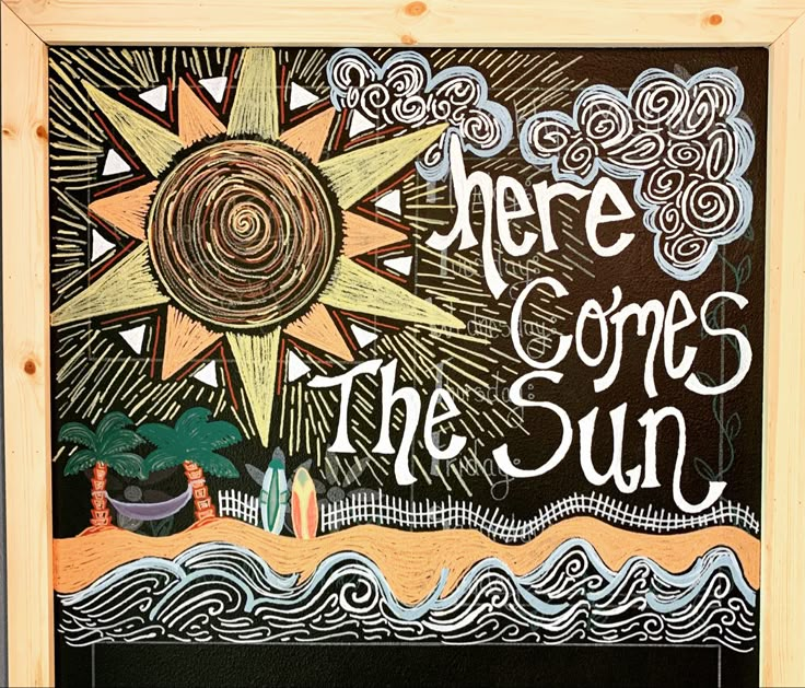 there is a chalk board with the words here comes the sun written in white on it