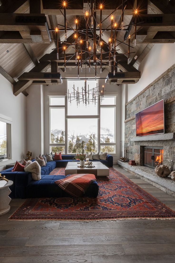 a living room with a couch, fireplace and large windows