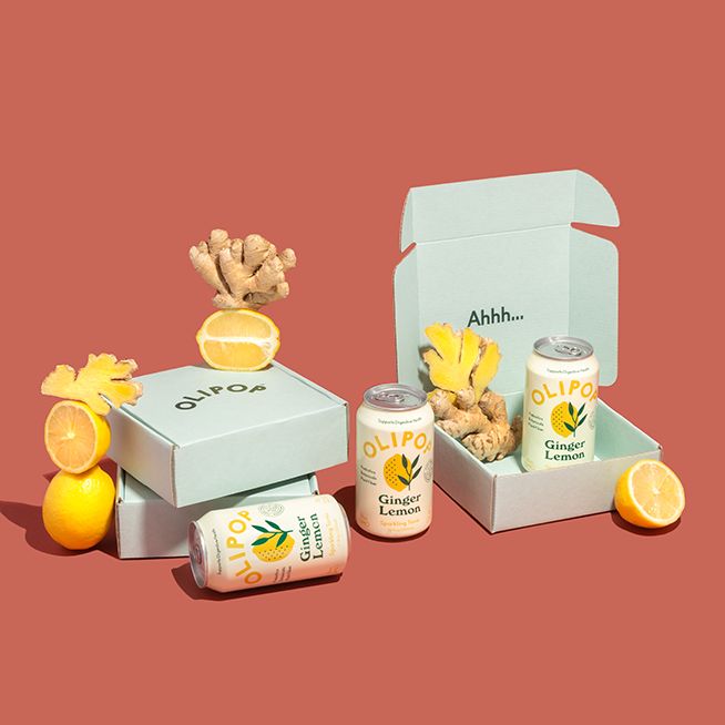 an open box with oranges, ginger and other foods in it on a pink background