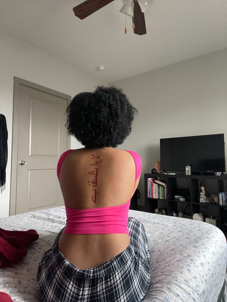 spine tattoo, arabic lettering, “love yourself first” Back Arabic Tattoo Women, Red Ink Tattoos Spine, Arabic Tattoo On Spine, Arabic Writing Spine Tattoo, Love Yourself First Back Tattoo, Islamic Tattoo Ideas, Love Yourself In Arabic Tattoo, Red Ink Spine Tattoo Black Women, Arab Back Tattoo