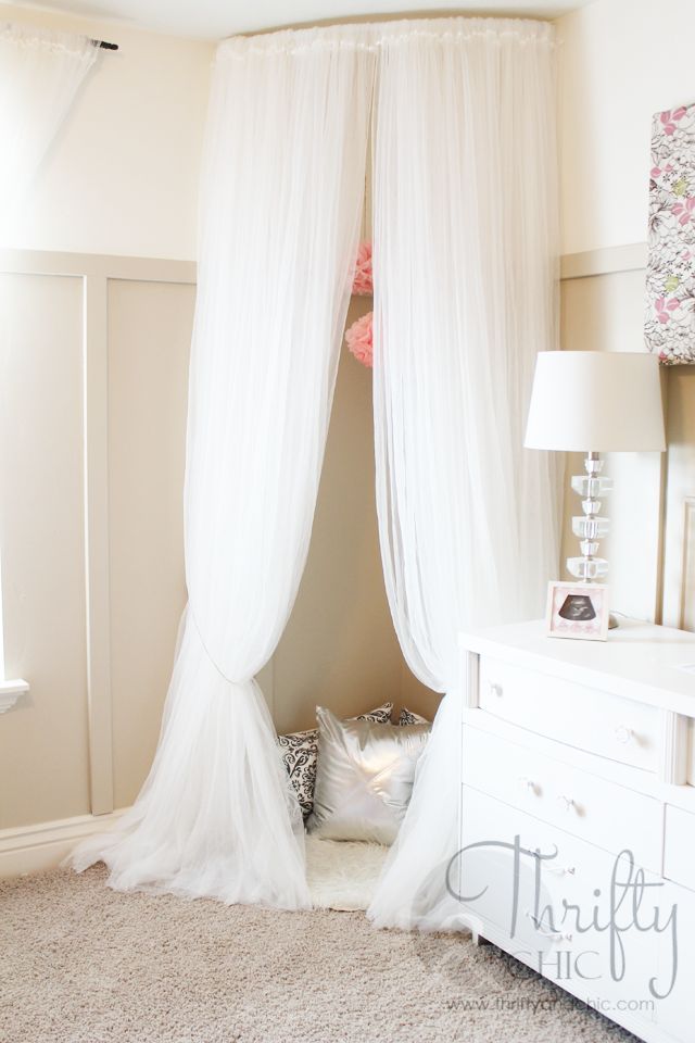 a white canopy bed in a bedroom next to a dresser