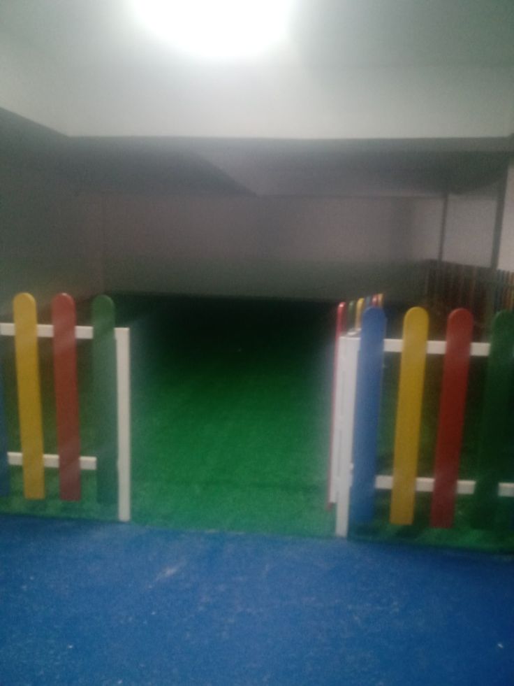 an indoor play area with colorful plastic fences