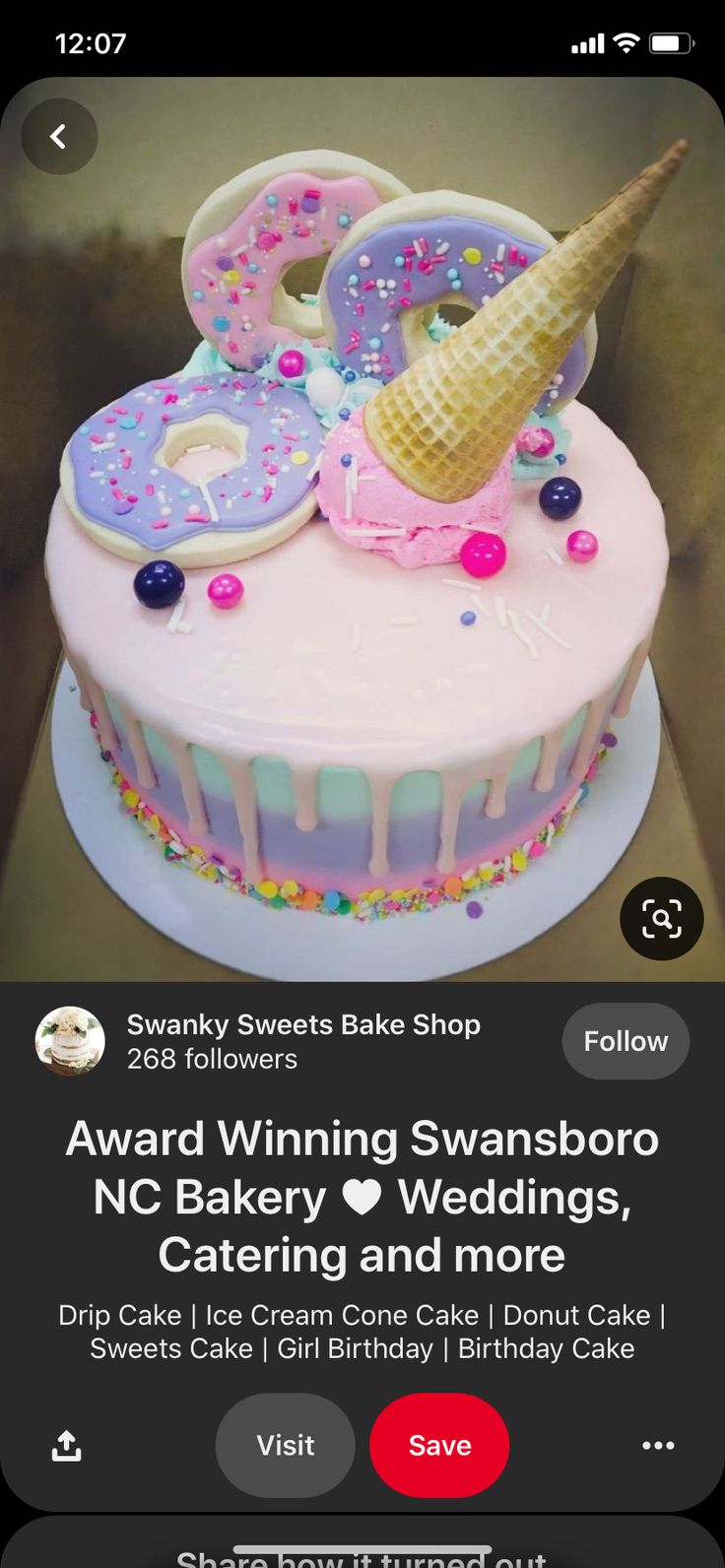 a pink cake with an ice cream cone on top and sprinkles all over it