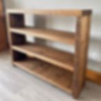 a blurry image of a wooden shelf in a room with white walls and wood flooring