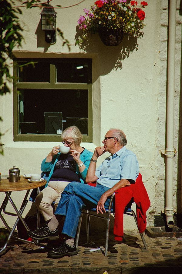 an older couple sitting outside drinking coffee