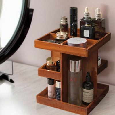 a mirror and some bottles on a table next to a shelf with cosmetics in it