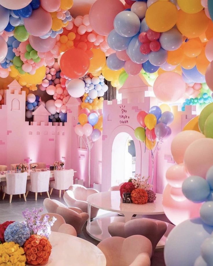 a room filled with lots of balloons and tables