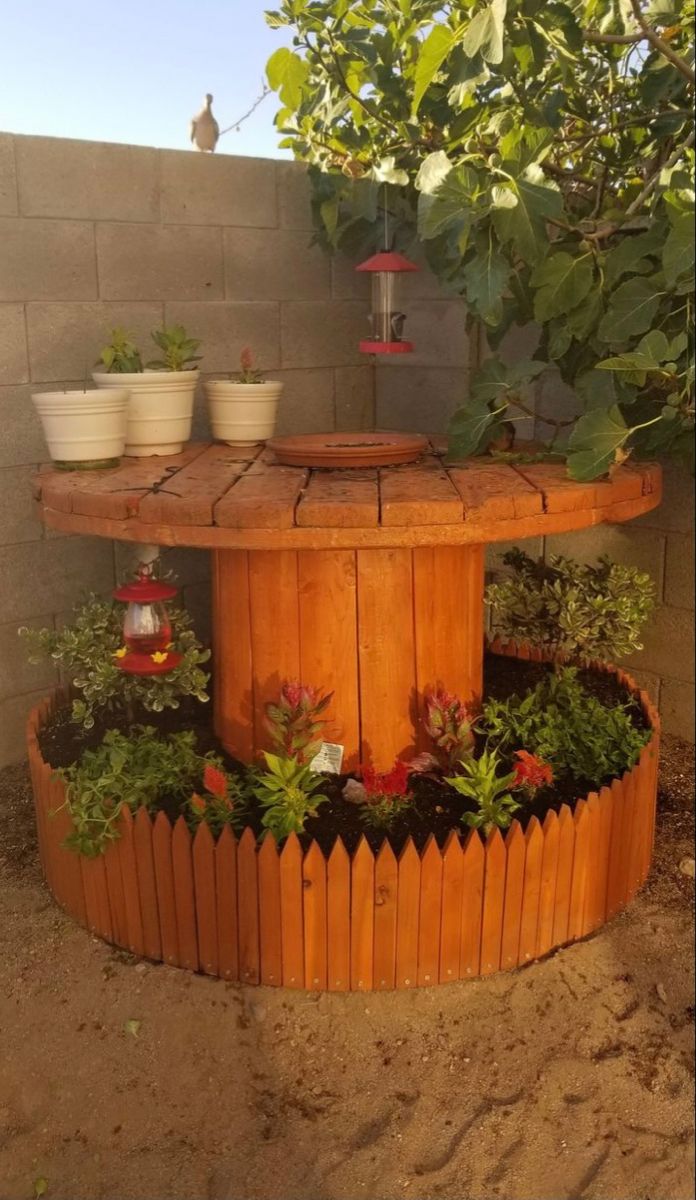 a wooden table surrounded by potted plants