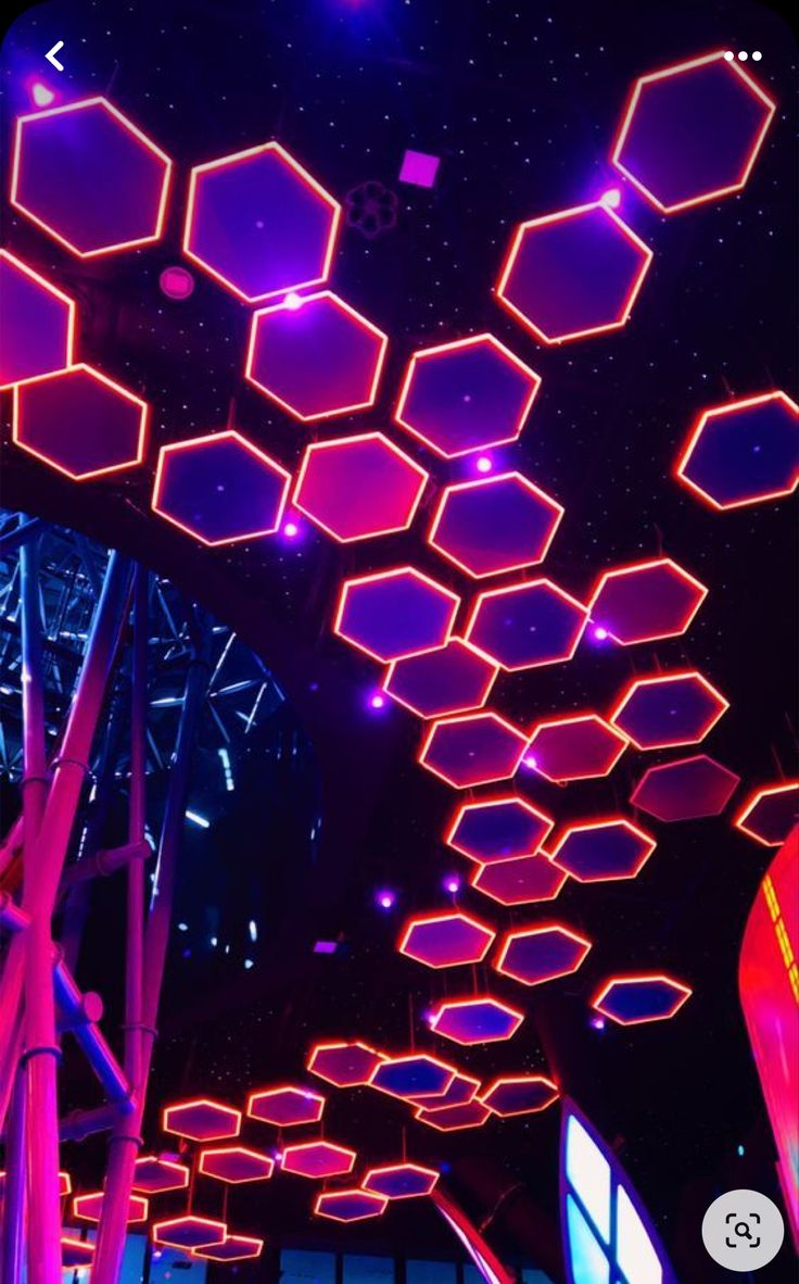 the ceiling is lit up with purple lights and hexagonal shapes on it's sides