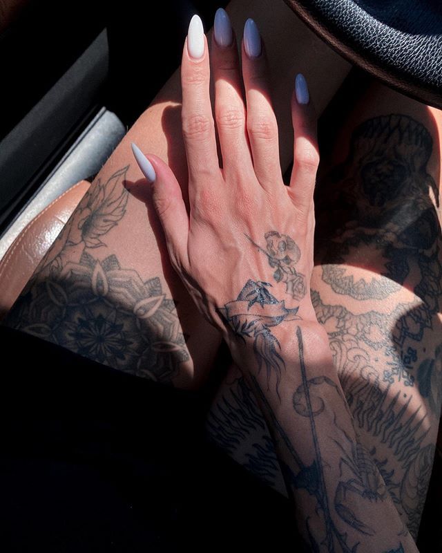 a woman with tattoos on her arm and hand