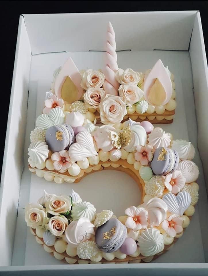 a cake in a box with flowers and unicorn ears on it