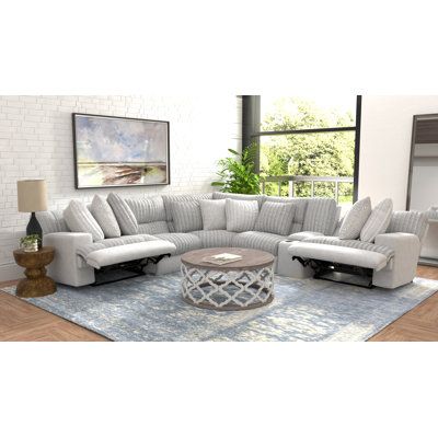 a living room filled with white furniture and a blue rug on top of a wooden floor