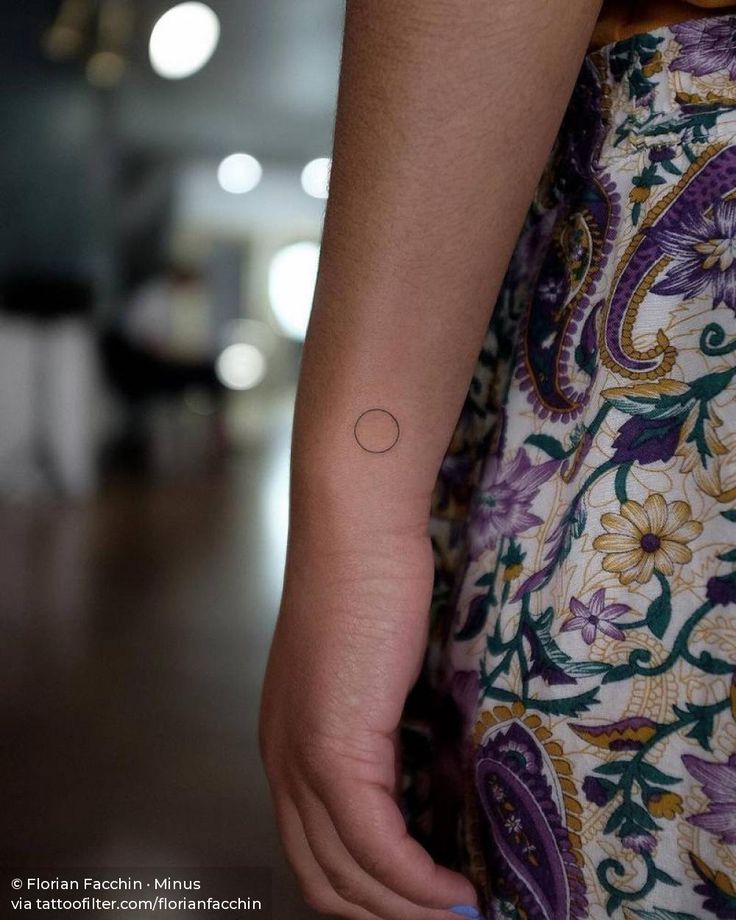 a close up of a person's arm with a small tattoo on it