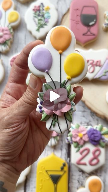 a person is holding up some decorated cookies