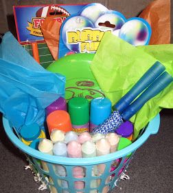 a blue basket filled with toys on top of a floor next to a bag and other items