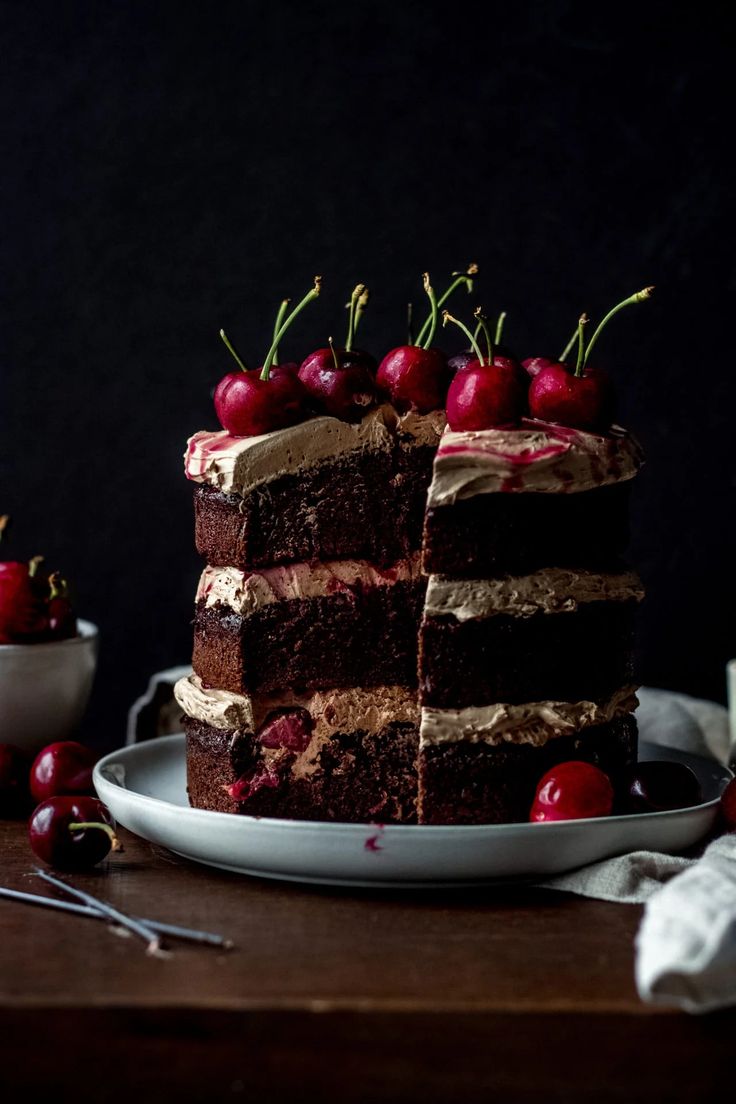 there is a chocolate cake with cherries on the top and two slices cut out