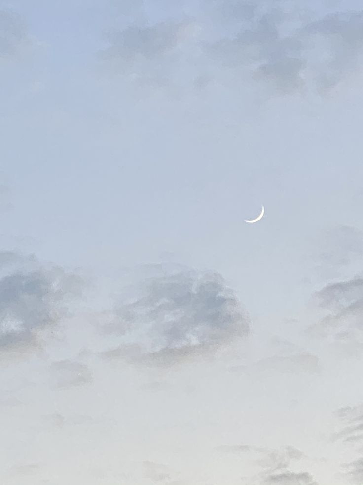 an airplane flying in the sky with a half moon