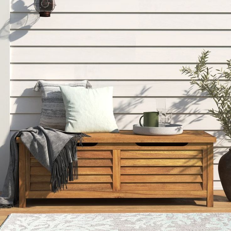 a wooden bench sitting on top of a patio next to a potted planter