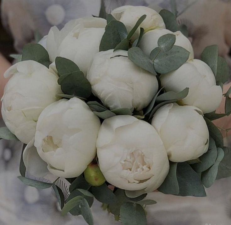 a bridal bouquet with white peonies and greenery