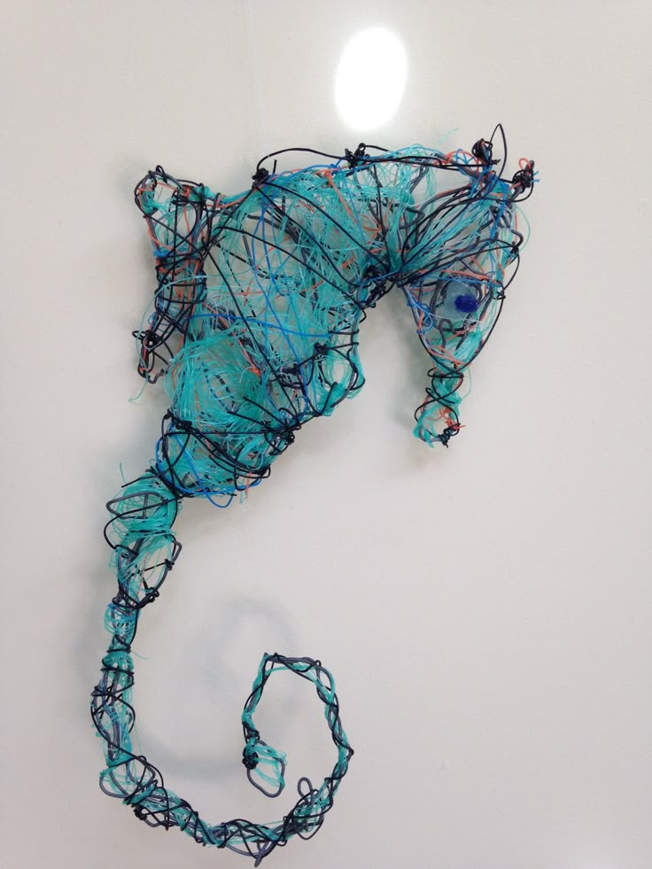 a piece of art that looks like a seahorse made out of string and wire