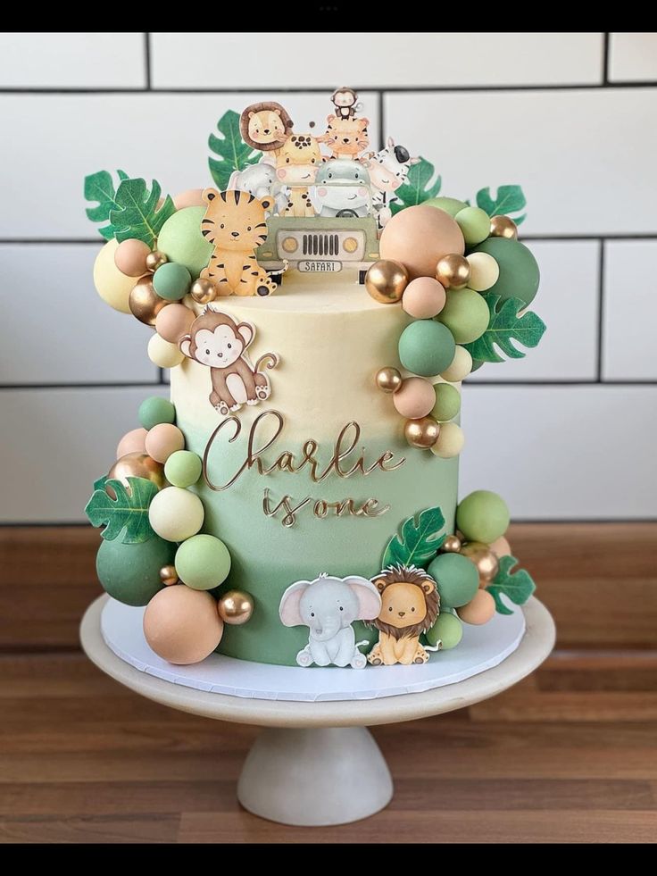 a cake decorated with jungle animals and greenery