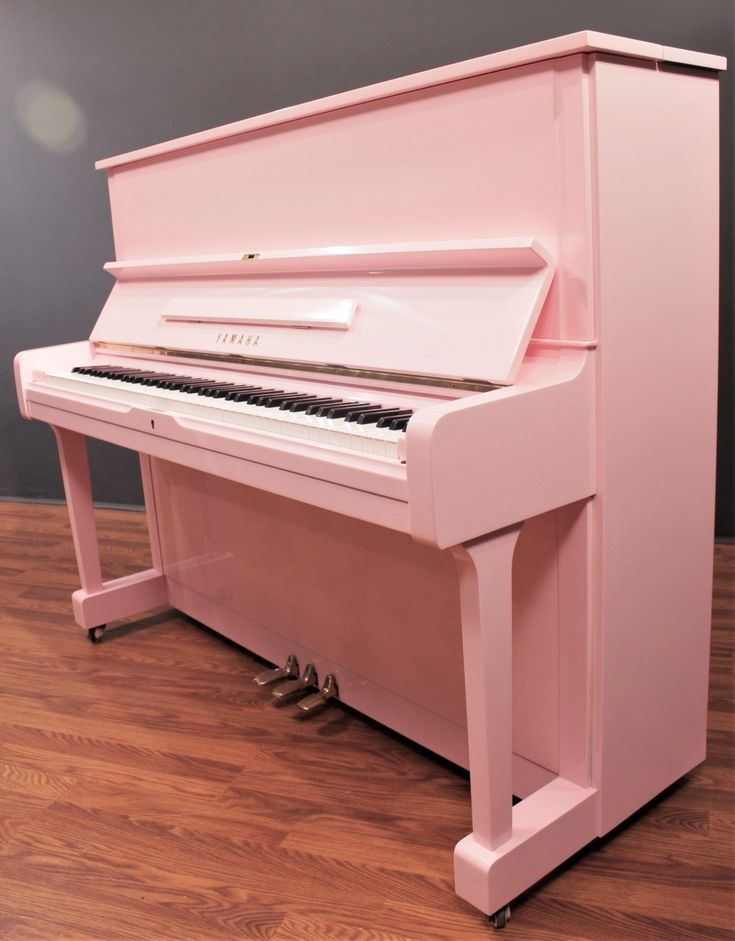 a pink piano sitting on top of a wooden floor