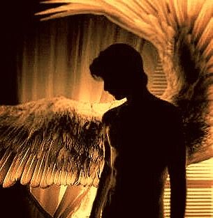 a man standing in front of a window with an angel wings on it's back