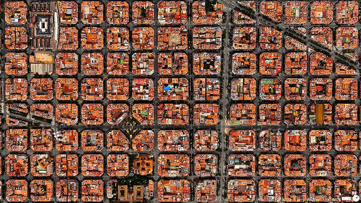 an aerial view of a city with lots of orange buildings and trees in the background